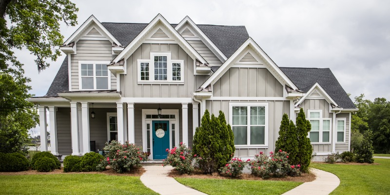 beautiful grey home with blue front door